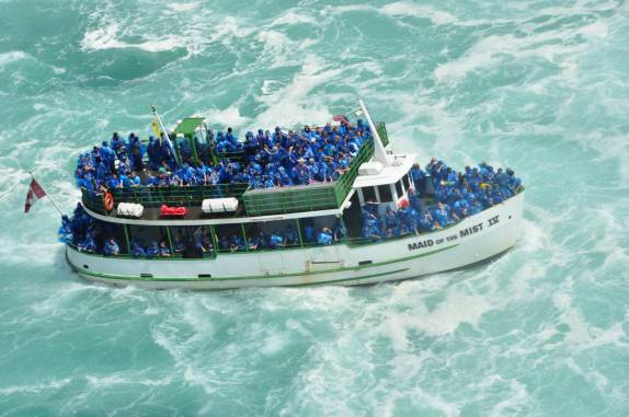 Barco abarrotado de turistas se aproxima das Niagara Falls, na fronteira do Canadá e Estados Unidos